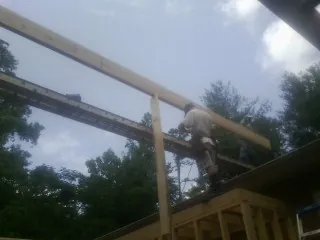 Carpenter setting a ridge beam over a new addition frame — Ice Dam Removal by Roofing Brothers in Jewell