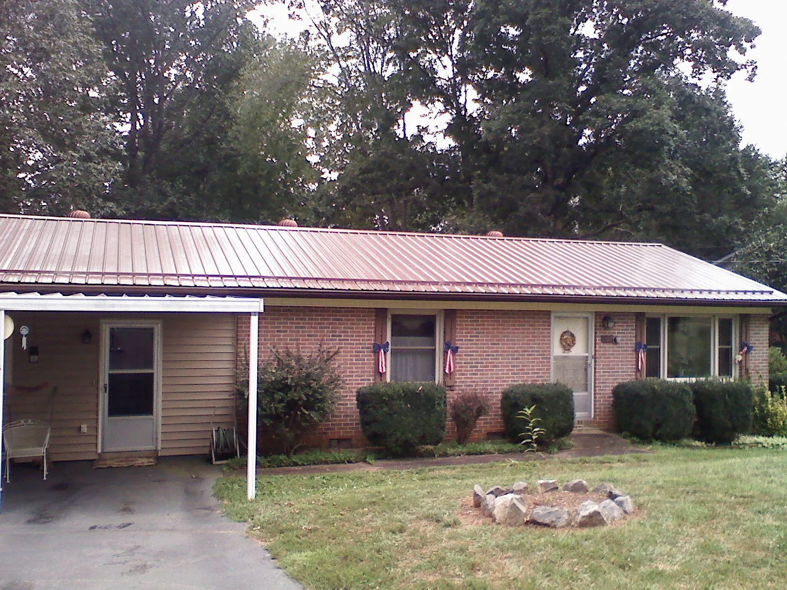 Bronze metal roof and carport on a brick ranch home — Roof Repair work by our crew in Jewell